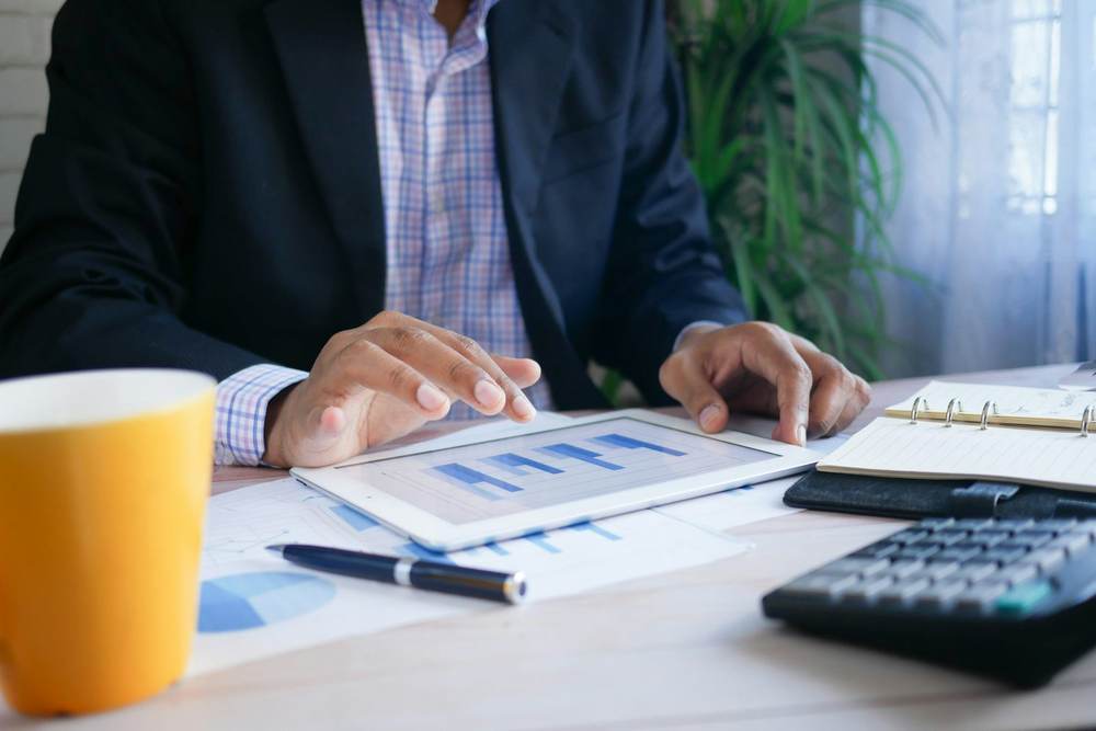 A director reviewing financial charts and data on a tablet