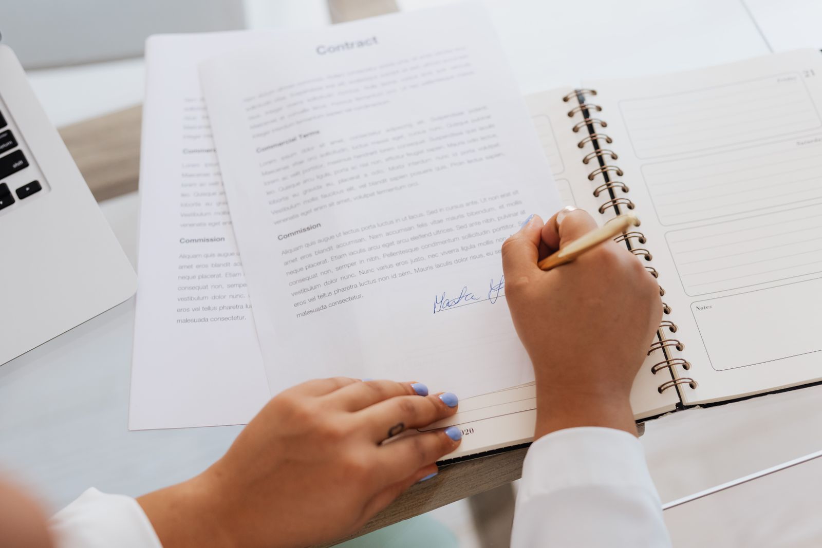 Hands signing a shareholder agreement document